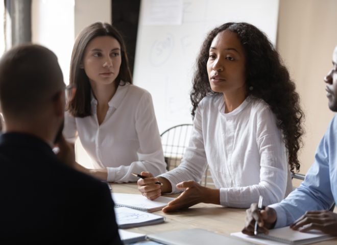 Young african businesswoman mentor teaching multiracial people during group briefing