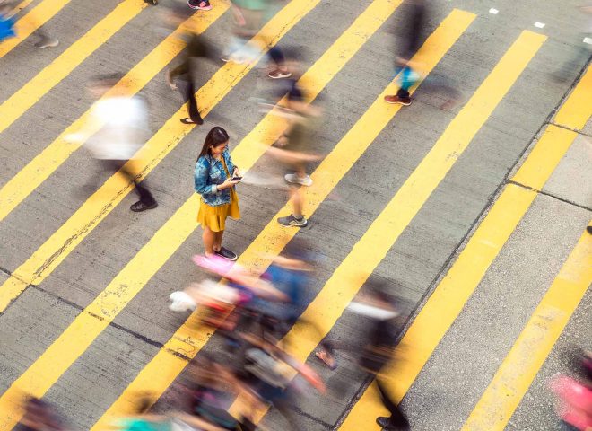 woman standing in busy street with blurred people in background